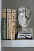 Phrenological head and books by Ian Fleming on a shelf in a London home UK