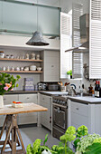 Pendant light in double height kitchen with shutters in South London schoolhouse conversion UK