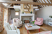 Teatray on ottoman with armchairs in beamed living room in Gloucestershire barn conversion UK