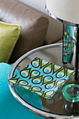 Turquoise saucer on glass topped coffee table in London home UK