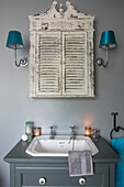 Salvaged bathroom cabinet above sink with lit candles in Hampshire home