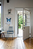 Stuhl und Kunstwerk vor der offenen Haustür eines Einfamilienhauses in Kent UK