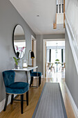 Blue velvet chairs and large mirror with console in hallway of Surrey home UK