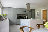 Light grey storage with extractor above island unit in Surrey kitchen UK