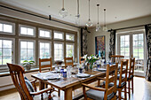 Esstisch und Stühle aus Holz mit Glaspendelleuchten in einem Haus in West Sussex, Großbritannien