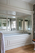Panelled bath in mirrored alcove of West Sussex home UK