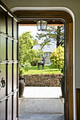 View through arched doorway to garden of Devon home UK
