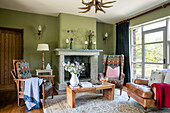 Armchairs and coffee table in green living room of Devon home UK
