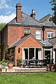 Gartenmöbel auf der Terrasse eines gemauerten Hauses in Hampshire England