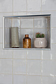Vases and cactus on recessed bathroom shelf in Northamptonshire cottage UK