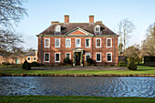 Symmetrical facade of Georgian country overlooking canal to the River Arrow Hertfordshire England UK