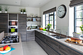 Dark brown units in modernised kitchen of 1900s Arts and Crafts style London home UK