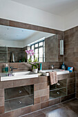 Double basins with large mirror in Art Deco style bathroom of London home UK