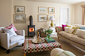 Ottoman and lit woodburner with armchair and sofa in Kent living room UK