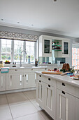 Christmas baking in modern white Hampshire kitchen with mirrored panels on door cupboards UK