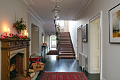 Wide entrance hall with carved fireplace and stairs in Hampshire home UK