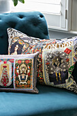 Dekorative Kissen auf einem tealfarbenen Sofa mit Knöpfen in einem Haus in London (UK)