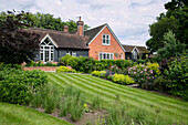 Sommergarten und Rasen eines ehemaligen Kutschenhauses aus dem Jahr 1900 West Sussex England UK