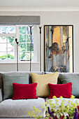Red velvet cushions with ?Massai? painting at window in former Victorian coach house West Sussex UK