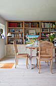 Regale aus alten Dielen mit Esszimmerstühlen aus Walnussholz am Tisch in einem Bauernhaus in Surrey, Großbritannien