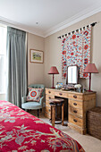 Schminktisch und Hocker aus Holz mit handgefertigten Textilien in einem Schlafzimmer im Norden Londons UK