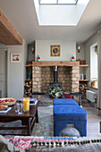 Holzofen und blaue Schemel mit Wänden in einem Cottage in den Cotswolds aus den 1840er Jahren in Oxfordshire UK