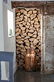 Firewood storage with antique milk churn in Grade II listed Georgian farmhouse Somerset, UK