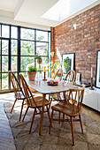 Dining table with skylight and steel framed windows in brick extension of Victorian family home Manchester UK