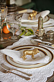Goldenes Löwenornament auf einem Tischset in einem unter Denkmalschutz stehenden georgianischen Landhaus in West Sussex, Großbritannien