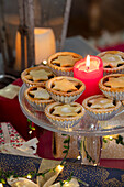 Mince pies und eine rote Kerze auf einem gläsernen Kuchenständer Hampshire UK