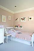 Artwork on walls in Middleton Pink with soft toys on bed in girl's room Hampshire UK