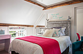Red blanket on bed in teenage girls room Surrey UK