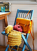Gelbe Strickerei mit Schulranzen auf blauem Stuhl in Isle of Wight home UK