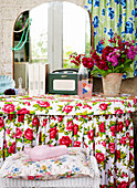 Mit Blumen gemusterter Schminktisch und Spiegel mit Schnittblumen in einem Haus auf der Isle of Wight, Großbritannien