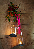 Kerzenhalter aus Glas hängen mit rosa Schleife in rustikaler Holzhütte Herbst UK