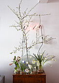Easter and spring flowers in jars and vase and neion Pink sign on wall