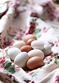 Brown and white hens eggs on a floral cloth