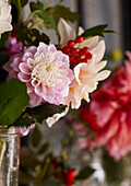 Detail of late summer blooms in glass jar Dahlias and Rosehip