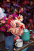 Bouquet of colourful autumnal Dahlias in a metal pot in the garden