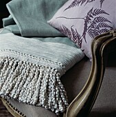 Wool blanket with fringed trimming on an upholstered armchair