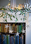 Festive mantel with paper star garland and sprigs of foraged greenery