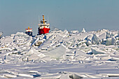 Coast Guard vessel leading a chemical tanker through ice