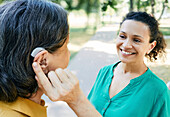 Woman adjusting hearing aid