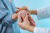 Doctor examining hand of senior patient with pain in wrist