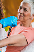 Woman receiving elbow treatment with meridian therapy pen