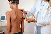 Pediatric doctor examining posture of a boy