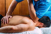 Physiotherapist massaging patient's shoulder