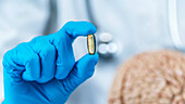 Female doctor holding model of brain and a placebo pill