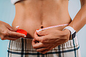 Woman measuring her waist size