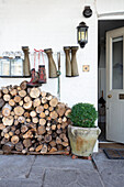 Entrance area with stacked firewood and hanging rubber boots